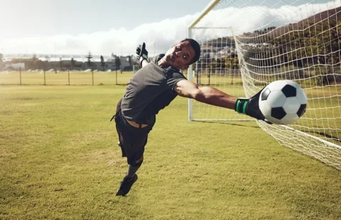a goalkeeper saving a shot - Futbolinfo.az