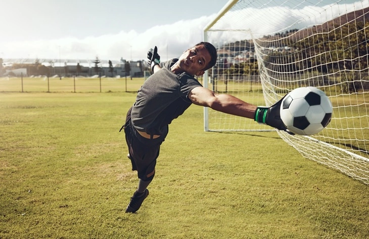 a goalkeeper saving a shot - Futbolinfo.az